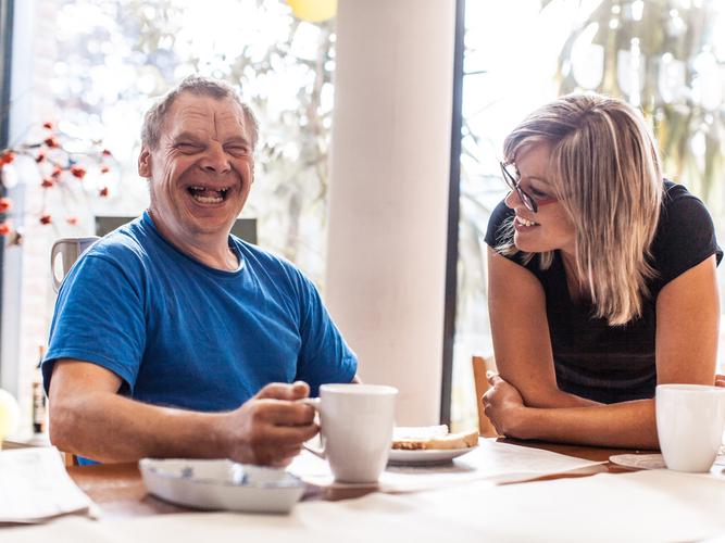 large_adult-man-portrait-with-a-down-syndrome-and-a-caregiver-picture-id639927062